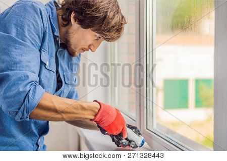 Man In A Blue Shirt Does Window Installation