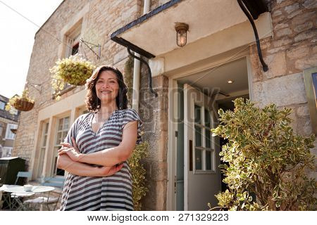 Female restaurant pub owner standing outside her business