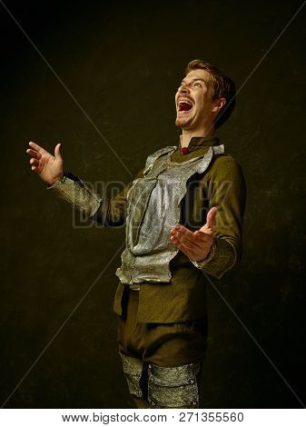 Medieval Happy Knight On Dark Studio Background. Portrait In Low Key Of Brutal Man In Tradishional R