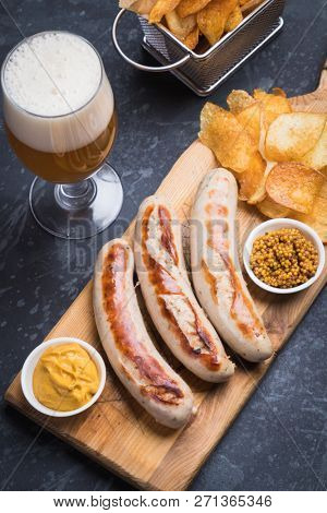 Grilled german sausages with mustard and fried potato chips