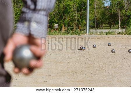 Senior People Prepared To Throw The Boules Ball In A Park In Outdoor Play