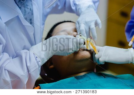 Dentist Coated Fluoride After Common Operation Of Cleaning Boy Mouth.