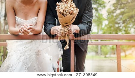 The Wedding Couple ,gride And Groom Holding Flower Bouquet In Hand,warm Light Tone,blurry Light Arou