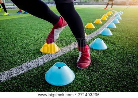 Soccer Player Jogging And Jump Between Cone Markers On Green Artificial Turf For Soccer Training.