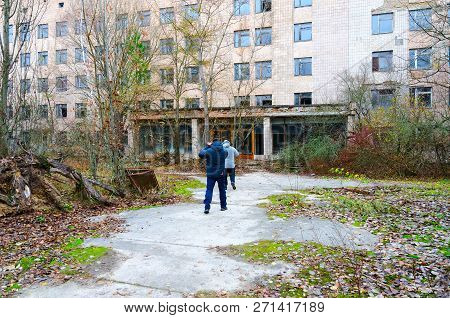 Pripyat, Ukraine - November 11, 2018: Unknown Tourists Go To Abandoned Building Of Hospital No. 126 