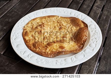 An Olive Oil Torta, A Traditional Spanish Sweet, On A Vintage Plate Over A Rustic Wooden Table.