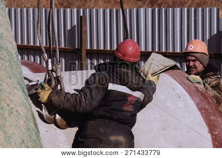 Irkutsk, Russia - March 24, 2017: Slinger At Work. Stroply Cargo. Worker In A Helmet.