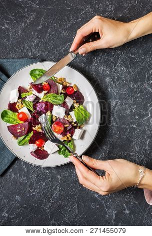 Dish With A Salad Of Feta, Beetroot, Cherry Tomatoes And Walnuts On A Stone Background. Female Hands