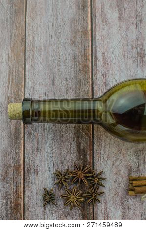 Hot Mulled Wine Drink With Lemon, Apple, Cinnamon, Anise And Other Spices In A Glass Cup Between Fir