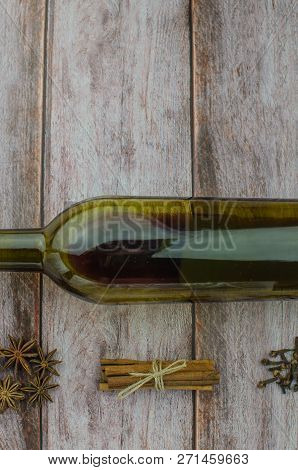 Hot Mulled Wine Drink With Lemon, Apple, Cinnamon, Anise And Other Spices In A Glass Cup Between Fir