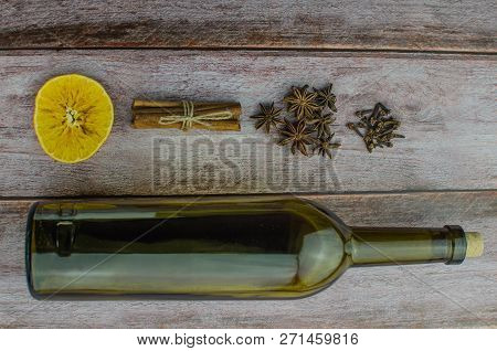 Hot Mulled Wine Drink With Lemon, Apple, Cinnamon, Anise And Other Spices In A Glass Cup Between Fir