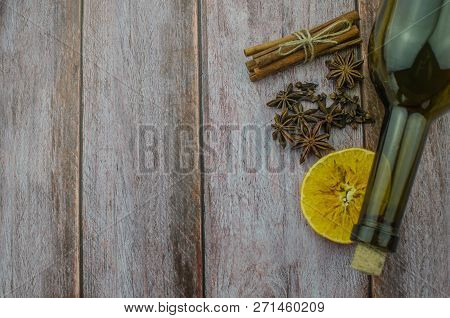 Hot Mulled Wine Drink With Lemon, Apple, Cinnamon, Anise And Other Spices In A Glass Cup Between Fir