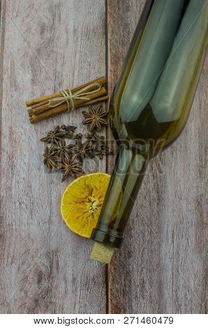 Hot Mulled Wine Drink With Lemon, Apple, Cinnamon, Anise And Other Spices In A Glass Cup Between Fir