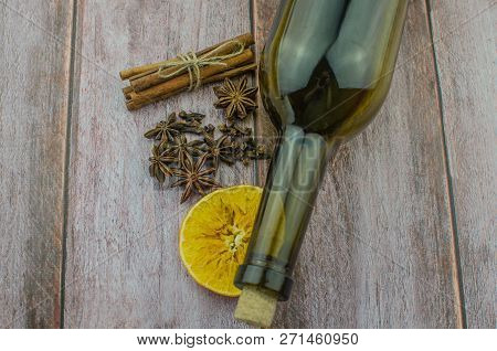 Hot Mulled Wine Drink With Lemon, Apple, Cinnamon, Anise And Other Spices In A Glass Cup Between Fir