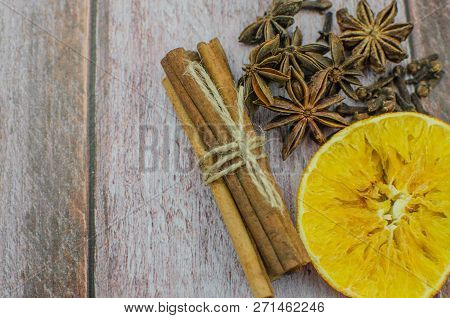 Hot Mulled Wine Drink With Lemon, Apple, Cinnamon, Anise And Other Spices In A Glass Cup Between Fir