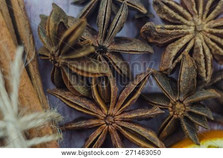 Hot Mulled Wine Drink With Lemon, Apple, Cinnamon, Anise And Other Spices In A Glass Cup Between Fir