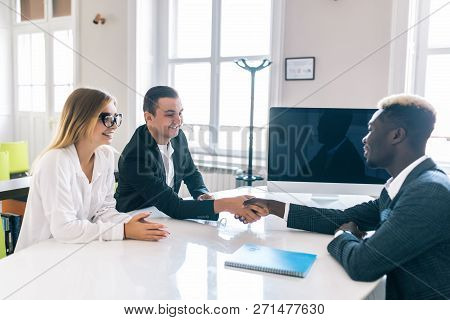 Afro American Investment Advisor Shaking Hands With Smiling Man While Consulting With Young Couple A