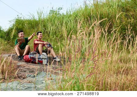 Happy Young People With Tablet Computer And Binoculars Birdswatching