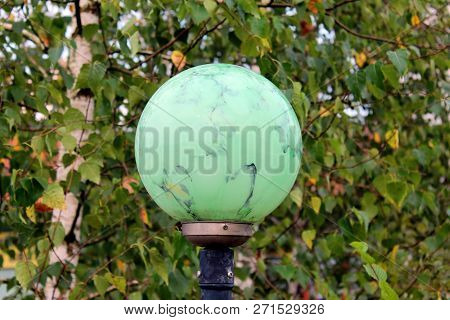Light Green Marble Like Texture Round Street Lamp Mounted On Metal Pole On Fresh Green Leaves Backgr
