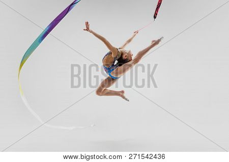 The Portrait Of Beautiful Young Brunette Woman Gymnast Training Calilisthenics Exercise With Blue Ri