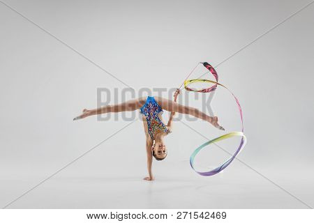 The Portrait Of Beautiful Young Brunette Woman Gymnast Training Calilisthenics Exercise With Blue Ri