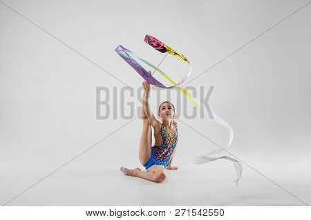 The Portrait Of Beautiful Young Brunette Woman Gymnast Training Calilisthenics Exercise With Blue Ri