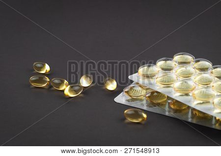 Fish Oil Omega3 Capsules And Blister Biologically Active Additive On A Dark Background Close-up Side