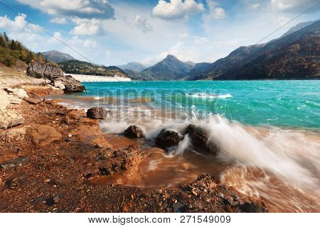 Sunny picturesque view of Roselend lake (Lac de Roselend) in France Alps (Auvergne-Rhone-Alpes). Landscape photography