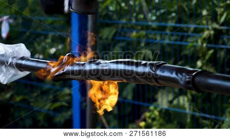 Blowtorch. Frame. Close-up Of Work With Blowtorch On Street On Background Of Trees. Roasting Of Pipe