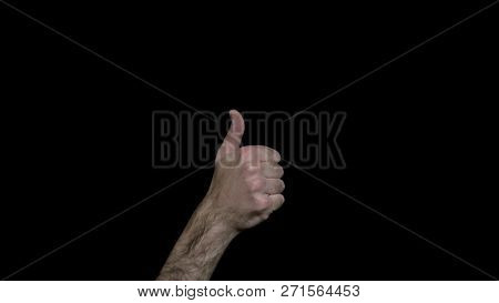 Close-up Of Male Hand Showing Thumb Up. Mens Hairy Hand Shows Hand Sign Like. Black Isolated Backgro