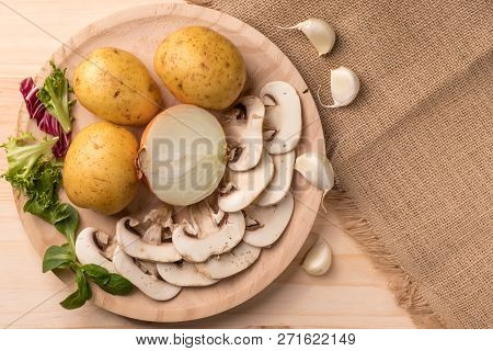 Appetizing Products For Cooking, Mushrooms, Potatoes, Onions, Garlic, Herbs On A Wooden Background W