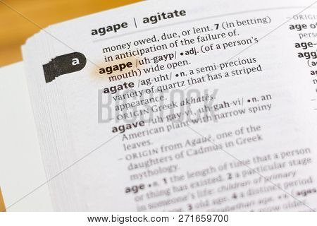 The Word Or Phrase Agape In A Dictionary Highlighted With Marker.