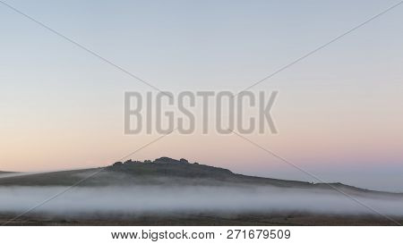 Stunning Foggy Sunrise Landscape Over The Tors In Dartmoor Revealing Peaks Through The Mist
