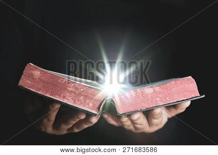 Light Coming From Book In Woman's Hands In Gesture Of Giving, Offering. Concept Of Wisdom, Religion,