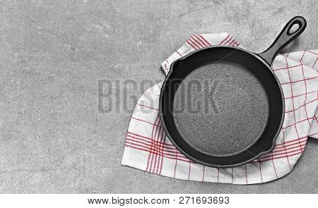 Cast Iron Pan On A Grunge Concrete Background With Copy Space. Empty Iron Pan, Top View Or High Angl