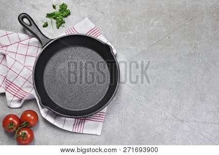 Cast Iron Pan On A Grunge Concrete Background With Copy Space. Empty Iron Pan, Top View Or High Angl