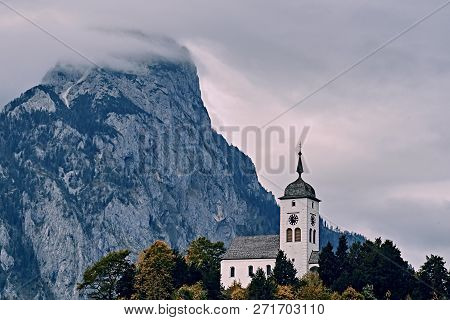 Beautiful Scenic Sunset Over Austrian Alps Lake. Church On The Rock With Clouds Over Traunstein Moun