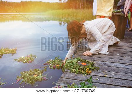 A Girl Lets Wreaths On The Water
