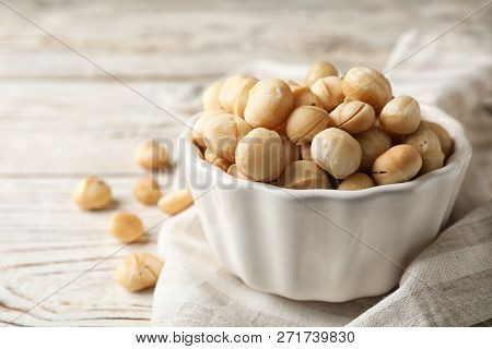 Bowl With Shelled Organic Macadamia Nuts And Space For Text On White Table