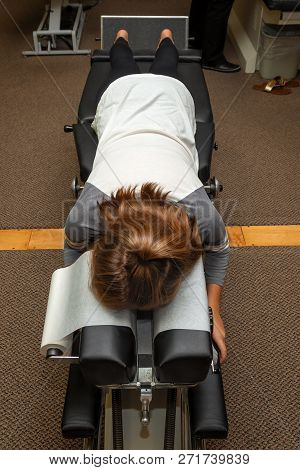 A Young Girl Lays On Her Stomach On A Chiropractic Adjustment Table Waiting For The Chiropractor To 