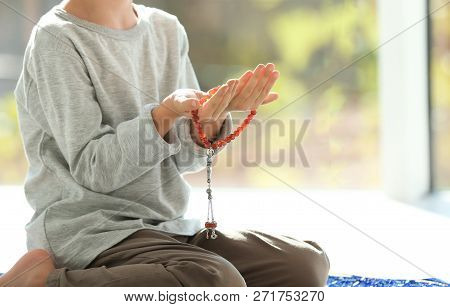 Little Muslim Boy With Misbaha Praying Indoors, Closeup. Space For Text