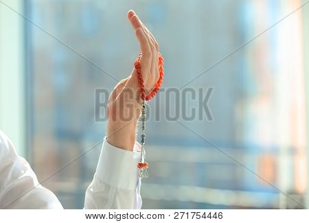 Muslim Man With Misbaha Praying Indoors, Closeup. Space For Text