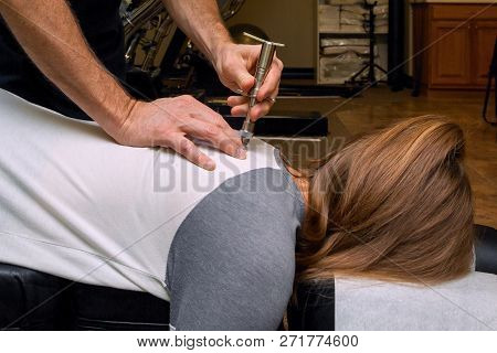 Chiropractor Uses An Integrator On The Back Of A Young Girl To Align Her Spine And Reduce Subluxatio