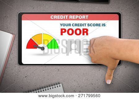 Poor Credit Score Technology Concept - Hand With Tablet Computer Shows Dislike, Thumb Down   On Ston