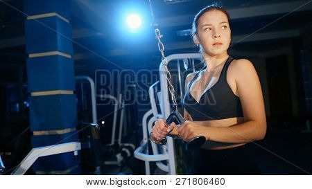 The Girl Performs The Extension Of The Arms For The Triceps In A Block Simulator.