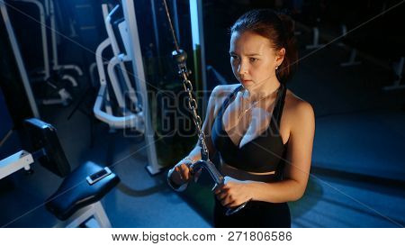 The Girl Performs The Extension Of The Arms For The Triceps In A Block Simulator.