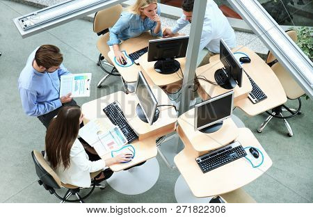 Top View Of Young Modern Colleagues In Smart Casual Wear Working Together While Spending Time In The