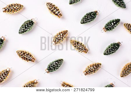 Christmas Or New Year Composition. Decorative Golden And Green  Pine Cones On Whitetextured Backgrou