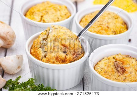 Polenta With Mushrooms In White Ramekin Bowls On Wooden Rustic Table. Close Up