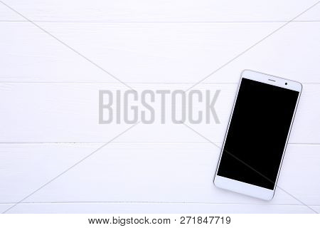 Mobile Phone With Blank Screen On White Wooden Table. Smartfone White